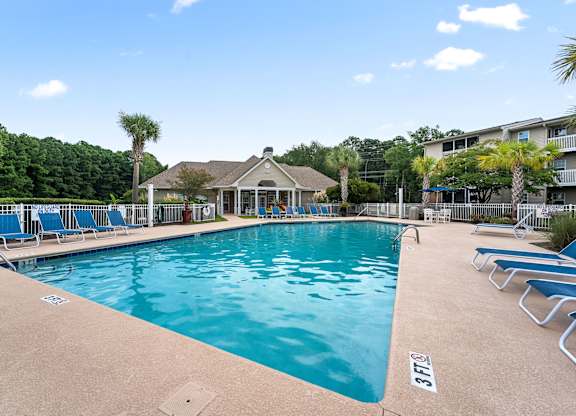 A swimming pool with a small pavilion and lounge chairs at Litchfield Oaks Apartments in Pawleys Island, 29585