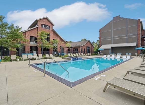 A pool with sun loungers and a building with the number 41125 on it.