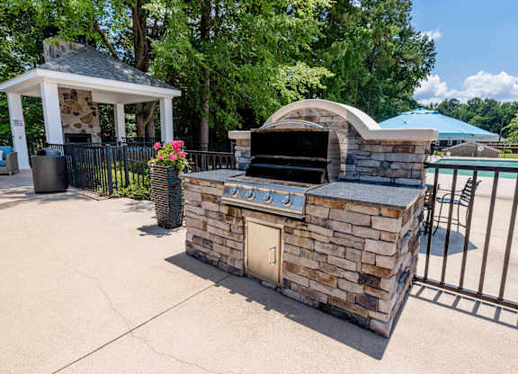 A stone oven is in the middle of a concrete area.