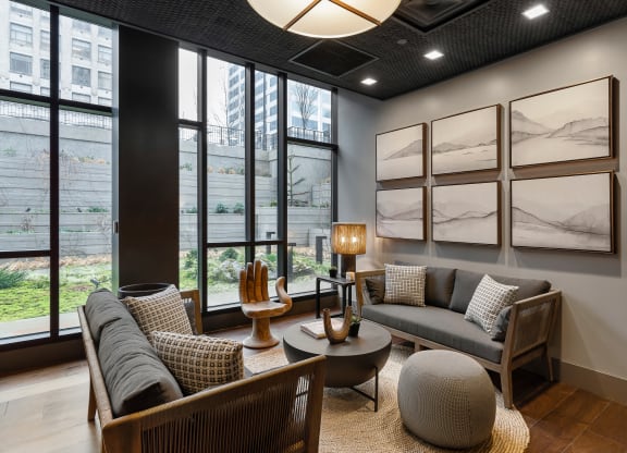 a living room with couches and chairs and large windows at Preston Centre, Columbus
