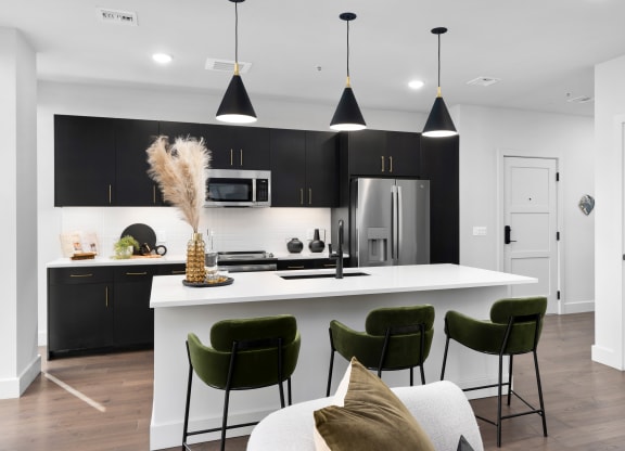a kitchen with a large white island with green chairs and a white couchat Preston Centre, Columbus