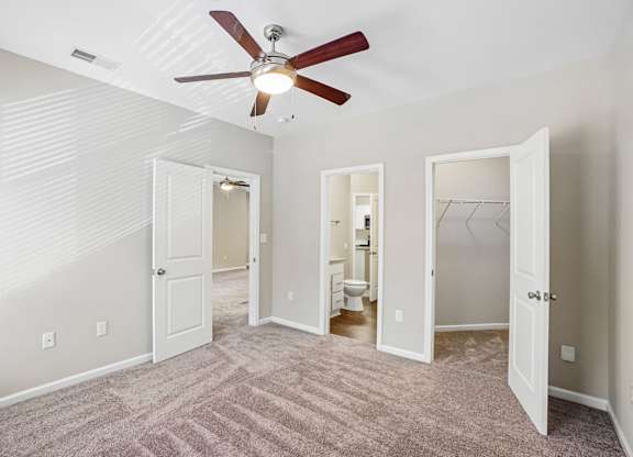 A room with a ceiling fan and carpeted floor.