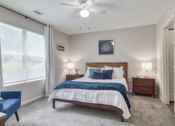 a bedroom with a bed and a ceiling fan and a window