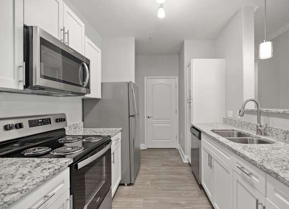 A kitchen with a black stove top oven and a black microwave above it.