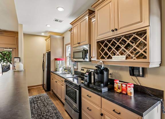 A kitchen with wooden cabinets and black countertops.