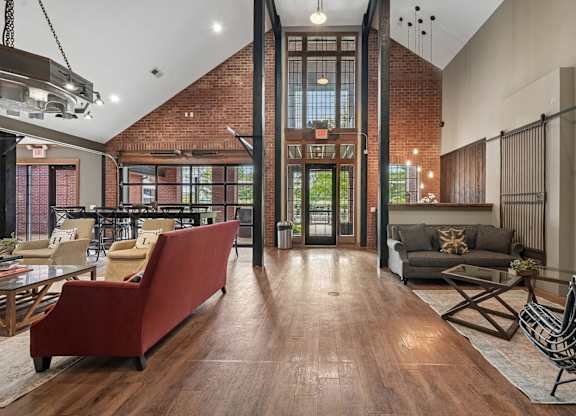 A living room with a red couch and a wooden floor.