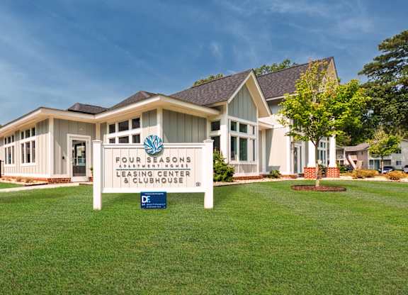 A building with a sign that says "Four Seasons Leasing Center & Clubhouse".