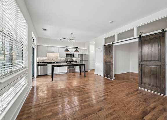 A room with a wooden floor and a table with chairs.