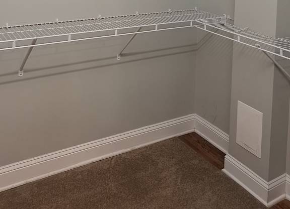 an empty closet in a room with a shelf on the wall