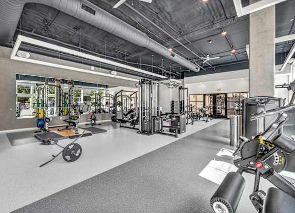 A gym with a variety of equipment including a rowing machine.