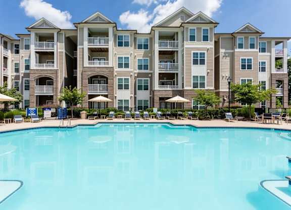 A large swimming pool in front of apartment buildings.