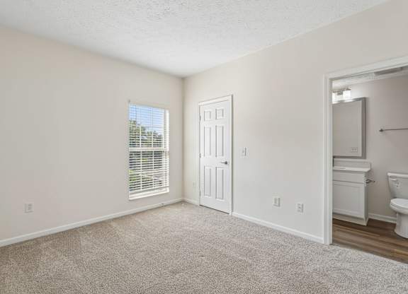 A room with a carpeted floor and a white door.