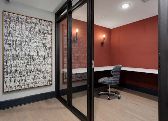 A room with a chair and a painting on the wall.