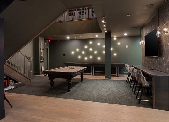a game room with a pool table and a bar at The Madison, Columbus, Ohio