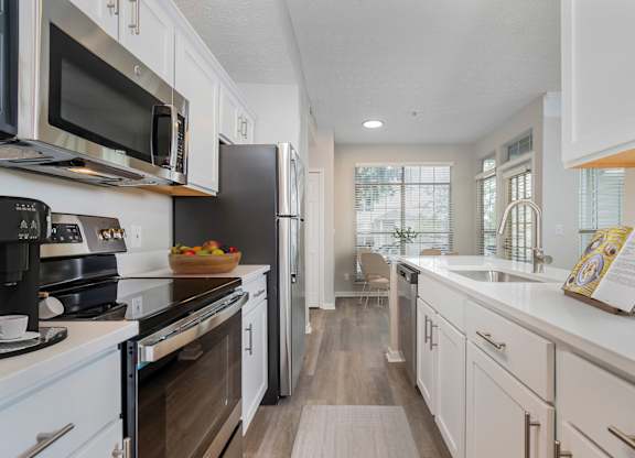 A modern kitchen with white cabinets and a wooden floor. at The Orchard, Dublin, 43016