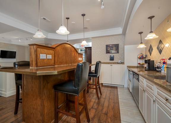 A kitchen with a bar area and a black chair. at Times Square, Dublin, Ohio