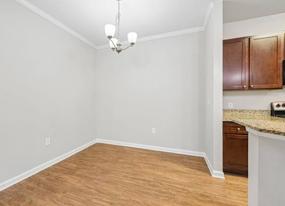 A room with wooden flooring and a chandelier.