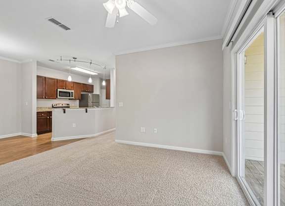 A spacious living room with a sliding glass door leading to a deck.