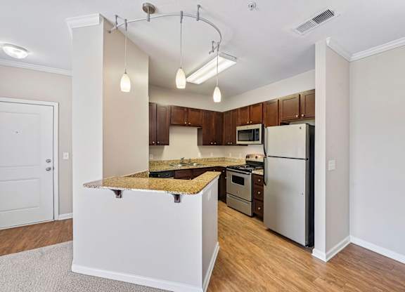 A kitchen with a white island and stainless steel appliances.