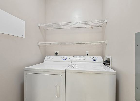 A white washing machine and dryer in a laundry room.