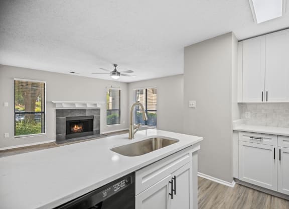 a white kitchen with a sink and a fireplace