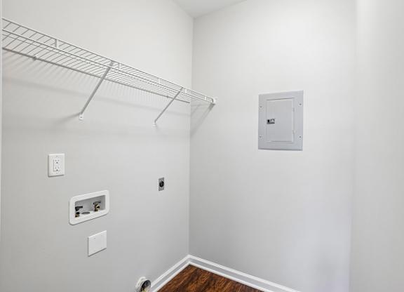 A white wall with a white door and a white shelf.