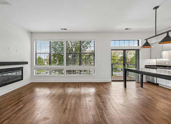 A modern living room with a fireplace and a view of the trees outside.