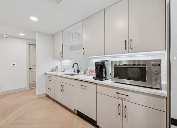 A kitchen with white cabinets and stainless steel appliances.