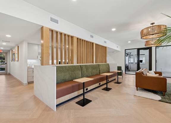 A long white reception desk with a green cushion on top.