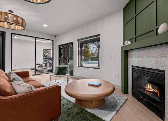 A modern living room with a fireplace and a brown couch.