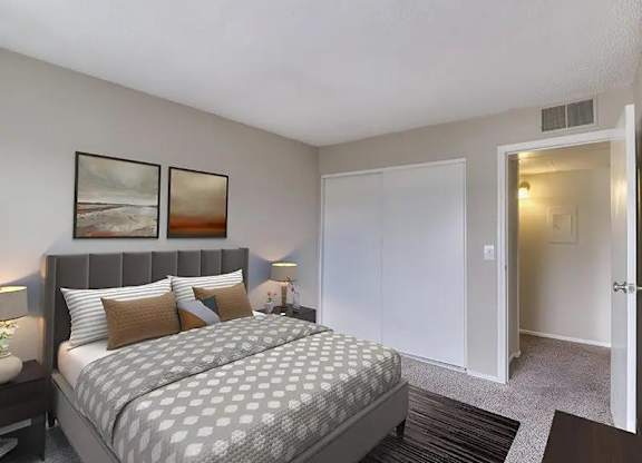 A bedroom with a bed, two lamps, and two pictures on the wall.