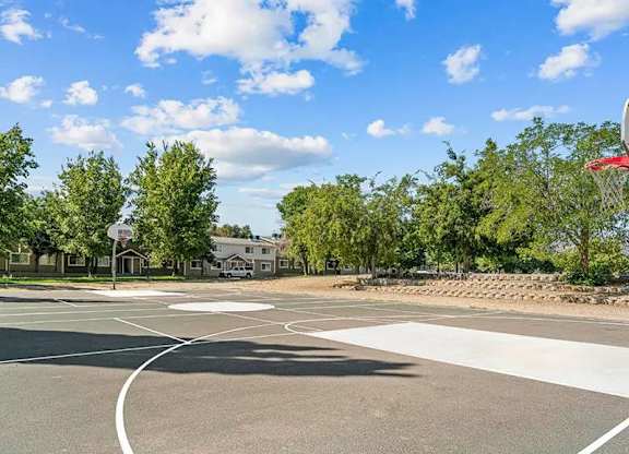 A basketball court with a hoop and a sign in the background.