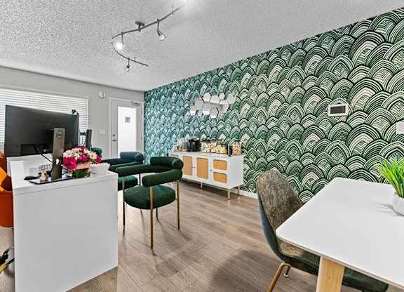 A room with a white desk and a green chair.