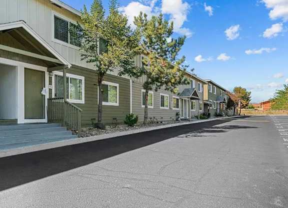A row of houses with a tree in front of the first house.