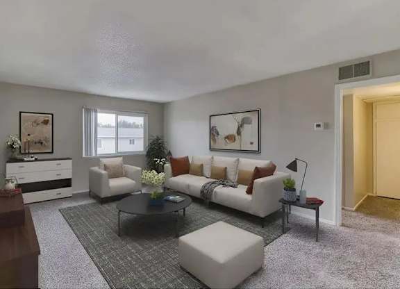 A living room with a white couch, a coffee table, and a grey rug.