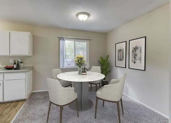 A dining room with a white table and chairs.