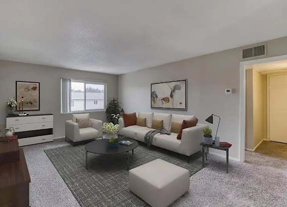 A living room with a white couch, a coffee table, and a rug.