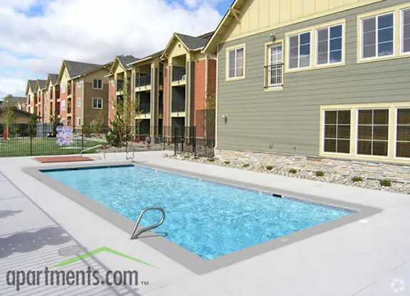 A swimming pool in front of apartment buildings.