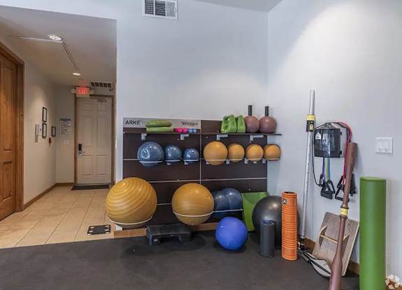 A gym room with exercise equipment and a green pole.
