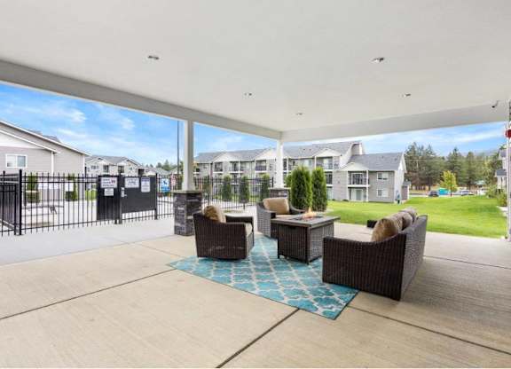 A patio with a couch and chairs is set up outside.
