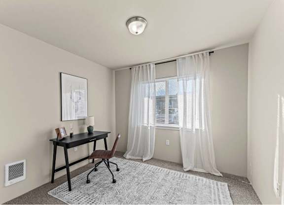 A room with a desk and chair in it.