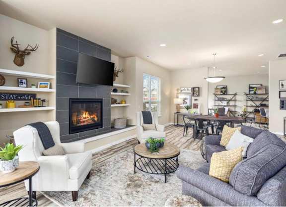 A living room with a fireplace and a television on the wall.