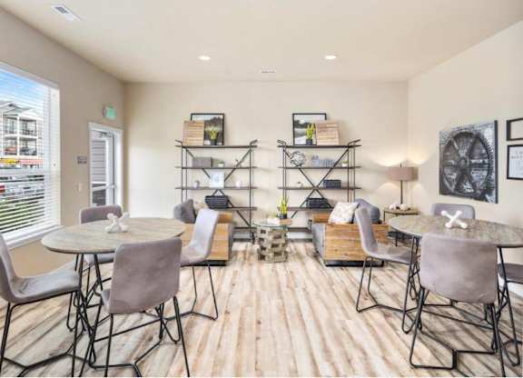 A dining room with a round table surrounded by chairs.