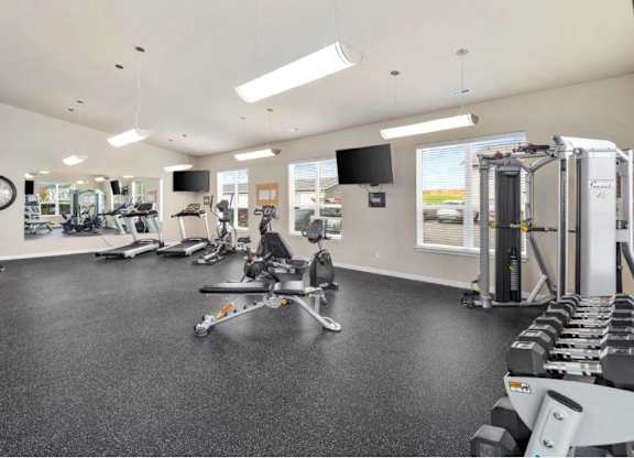 A spacious gym with a variety of equipment including treadmills, weights, and exercise machines.