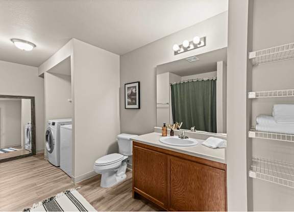 A bathroom with a toilet, sink, and a washing machine.