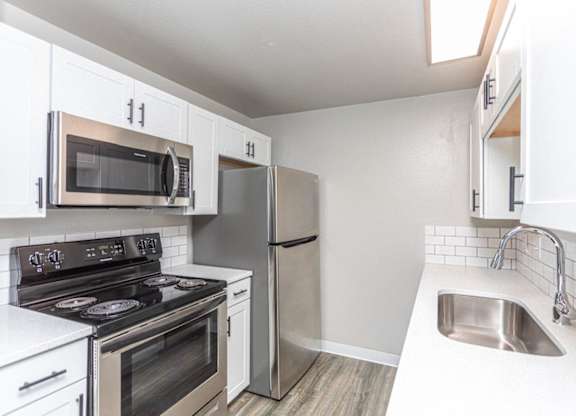 A kitchen with white cabinets and stainless steel appliances.