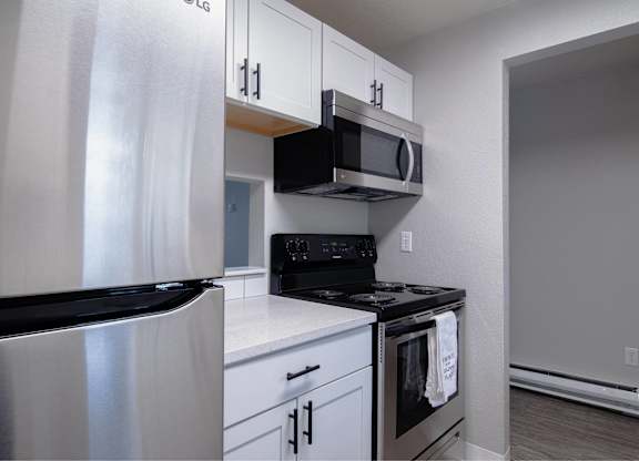 A kitchen with white cabinets and stainless steel appliances.