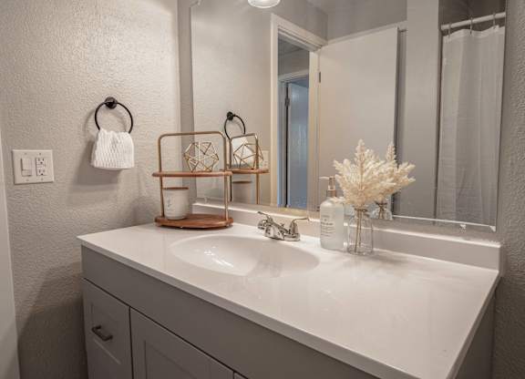 A white bathroom sink with a white towel hanging on the towel ring.