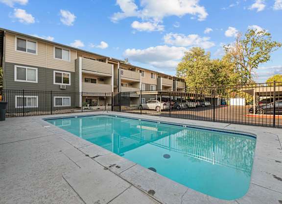 A small pool in a courtyard surrounded by a fence.