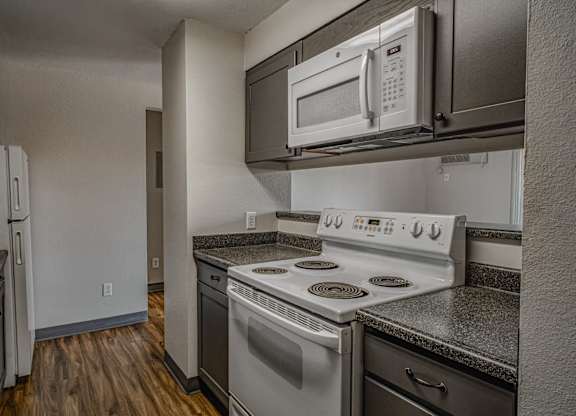 A kitchen with a stove, oven, and microwave.